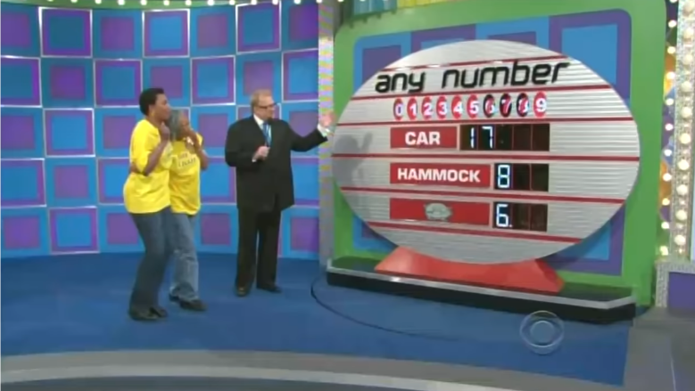 Contestants play the pricing game 'Any Number' on stage, featuring a large board with prizes including a car and a hammock, as the host guides them through the game.