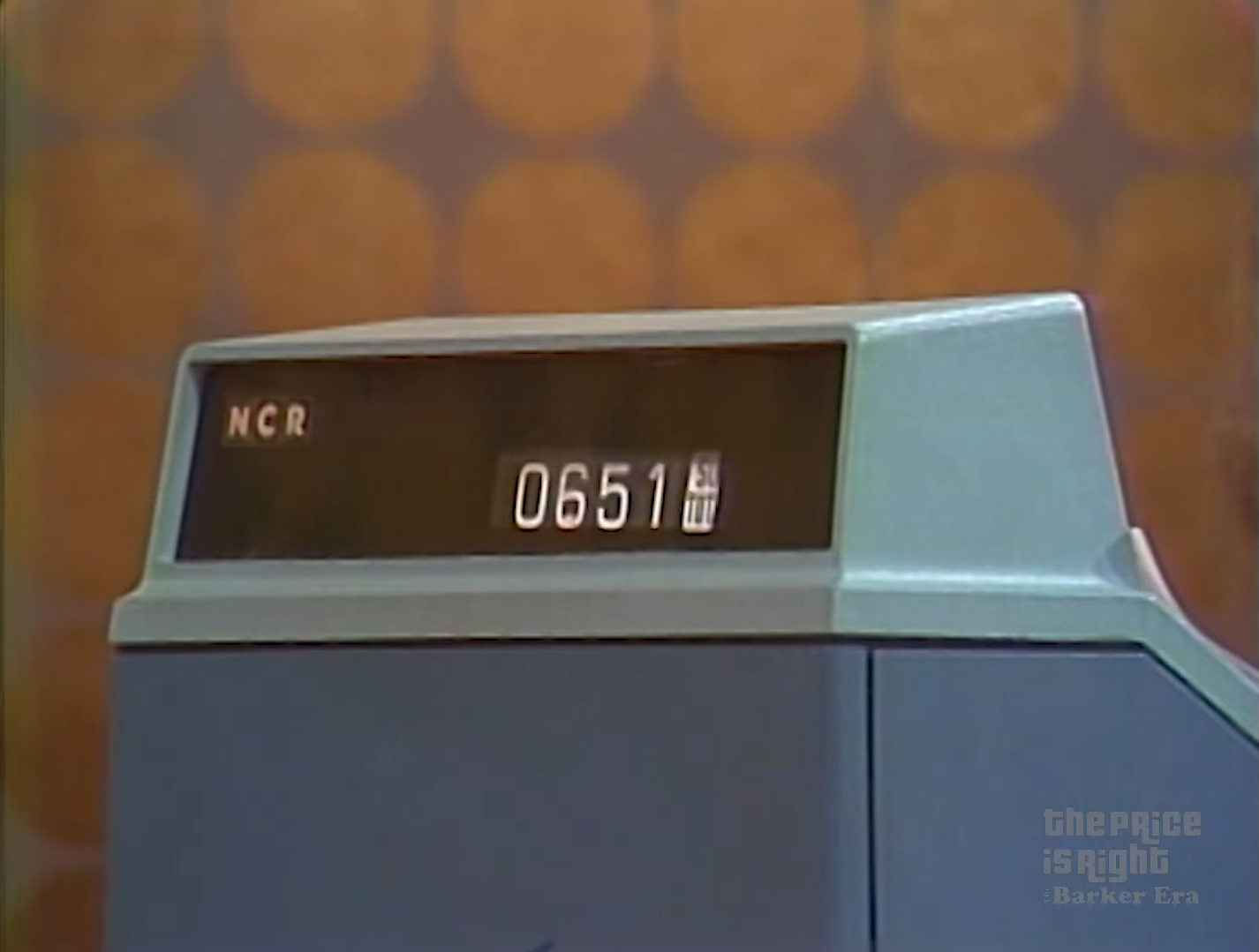 Close-up of a vintage cash register displaying the total amount of .51, with a blurred retro background.