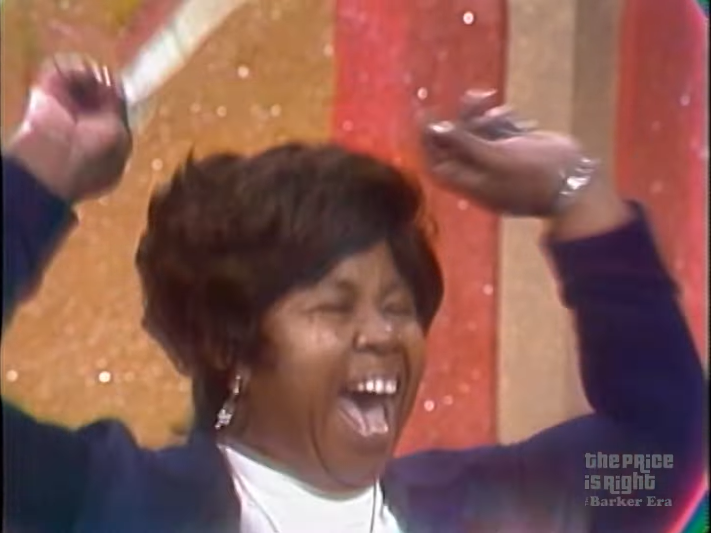 Contestant celebrating a win on the Price is Right, raising arms in joy against a colorful backdrop.