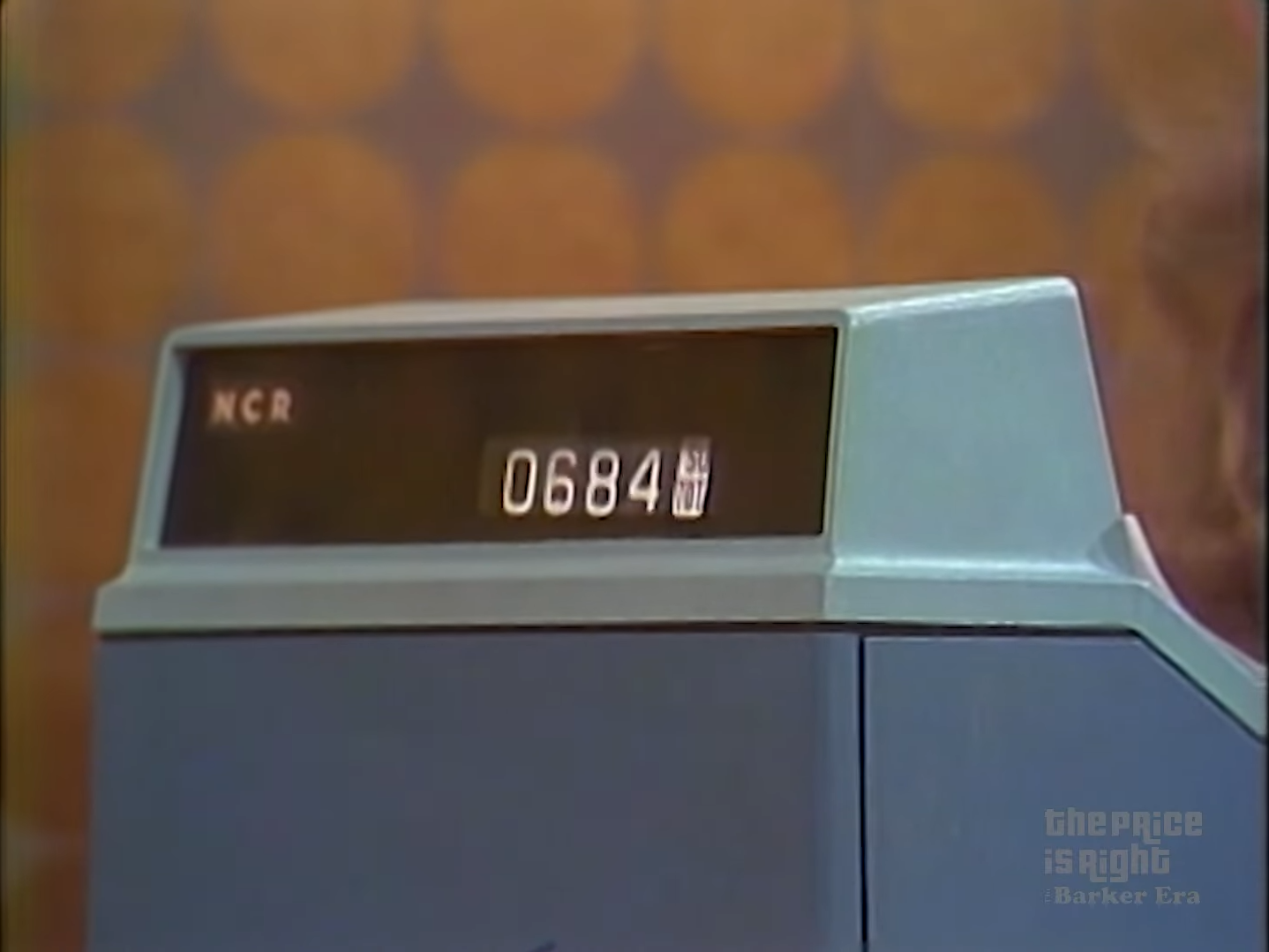 Close-up of an old-fashioned cash register displaying the total amount of .84 during a game show segment.