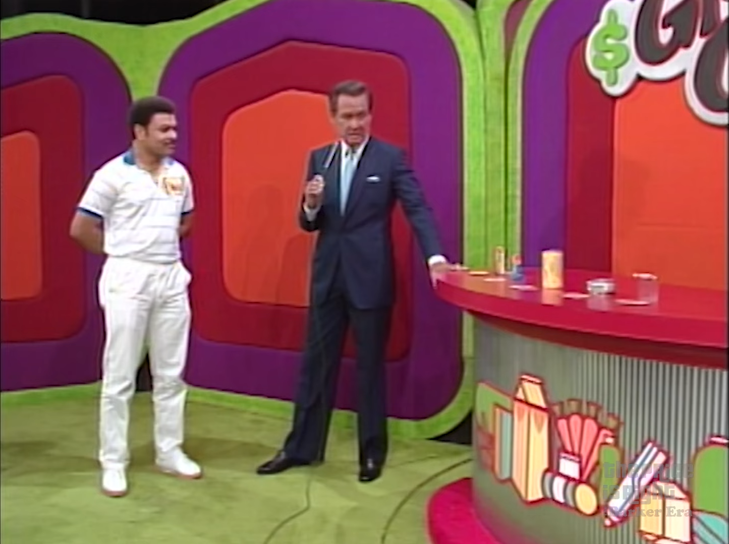 Contestant and host discussing the Grocery Game; various grocery products displayed on a colorful set.