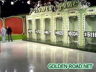 A game show set featuring six colorful shower stalls with displayed prices, where contestants can choose stalls for rewards.
