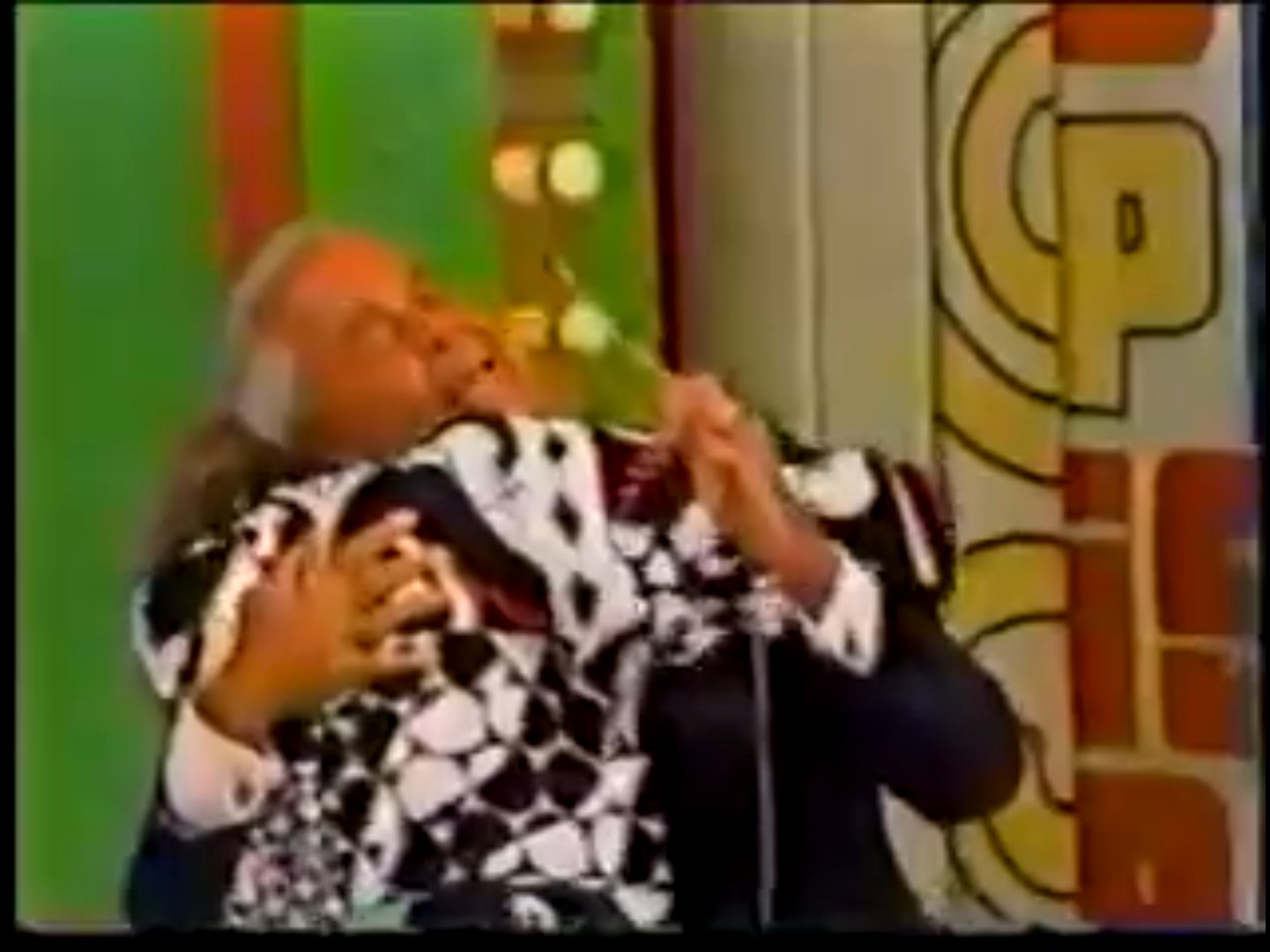 A joyful moment on a game show, featuring a host embracing a contestant in excitement.