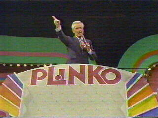 Bob Barker standing at a podium with the word 'PLINKO' prominently displayed in colorful letters beneath him.