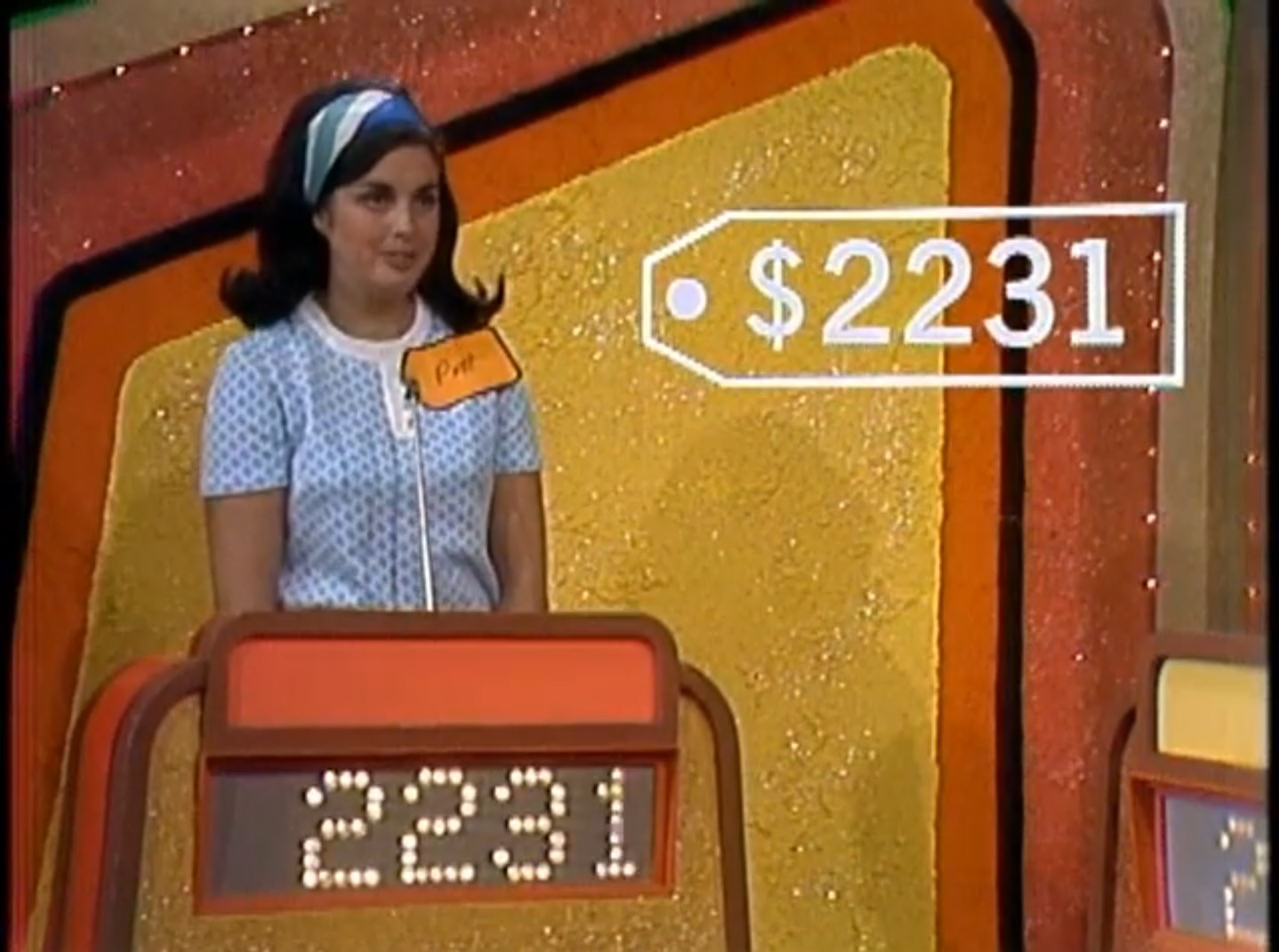 Contestant Pat stands behind a podium displaying the bid amount of 31 during a game show.