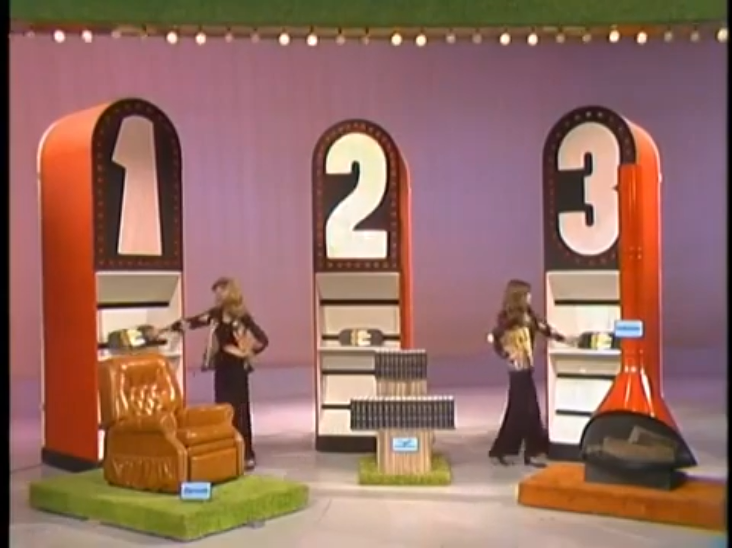 Contestants interacting with three prize displays labeled 1, 2, and 3 during the 'Most Expensive' game on 'The Price is Right'.