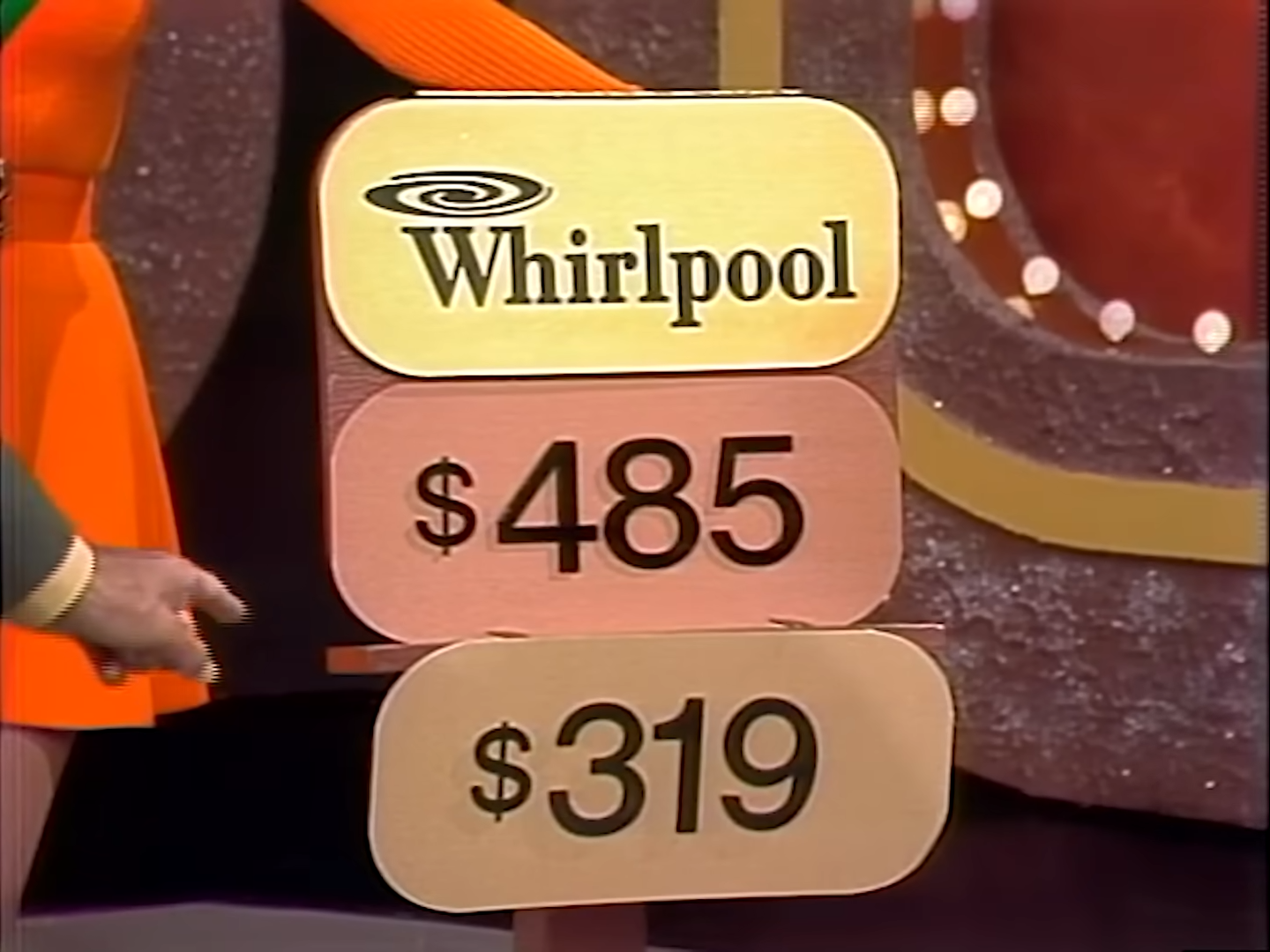 A game show set displaying a Whirlpool refrigerator with two price tags: 5 and 9.