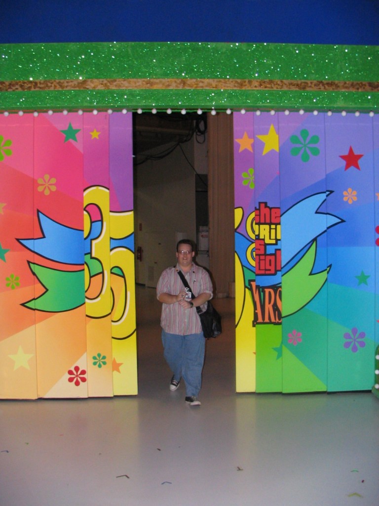 A person walking through a colorful doorway decorated with stars and patterns, representing the 35th season of a show.