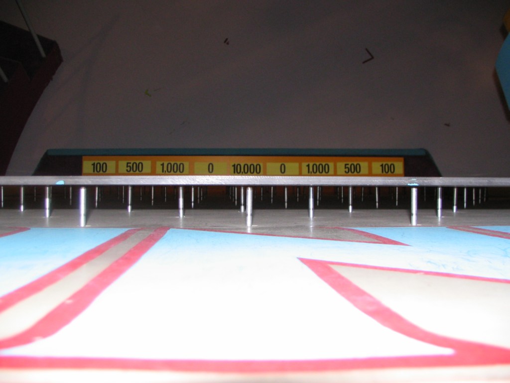 View of a game show stage highlighting scoring amounts on a display board.