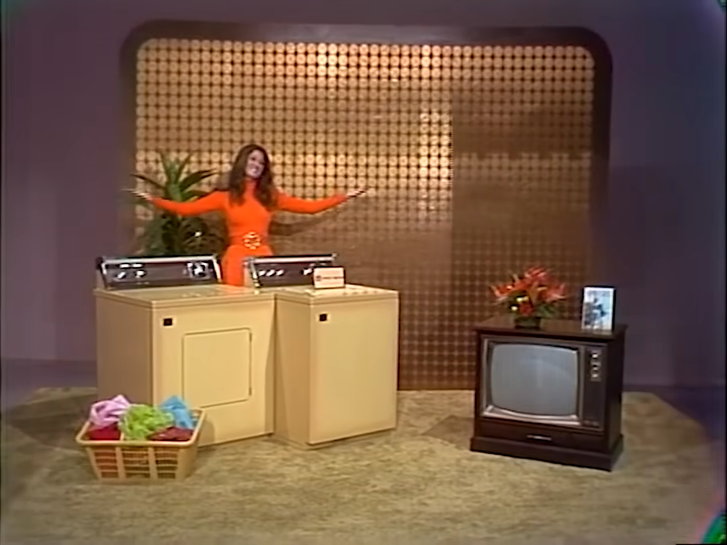 A model on The Price is Right in 1972 shows off a washer/dryer and a television set.