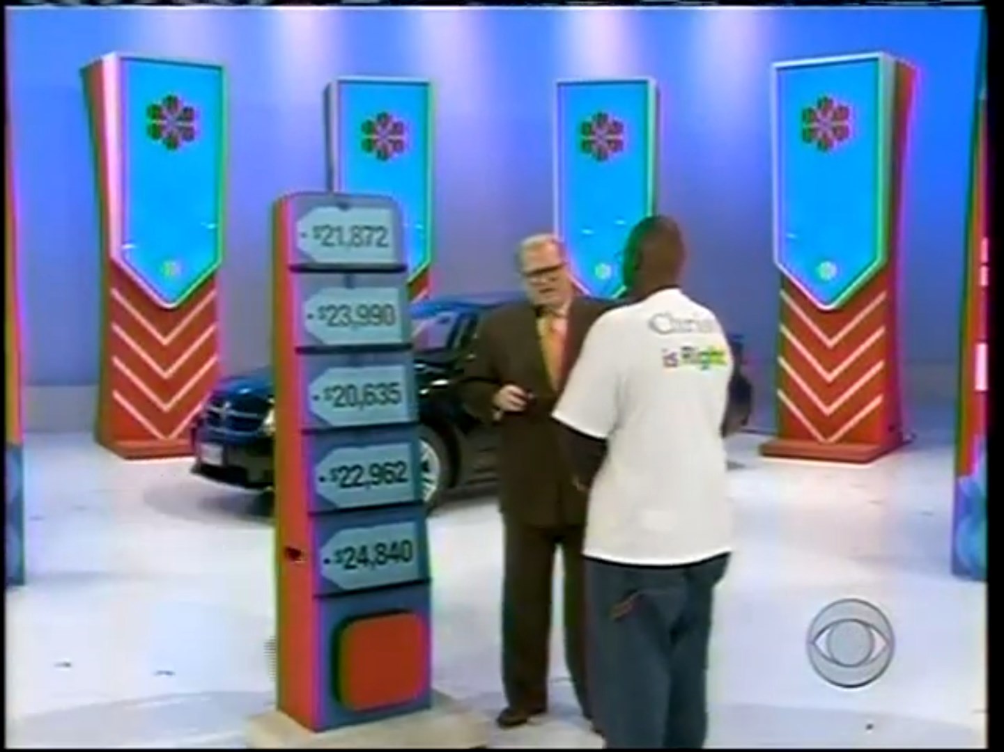 Contestant and Drew Carey interact in front of the 'Five Price Tags' game board, showcasing five price options for a prize car.