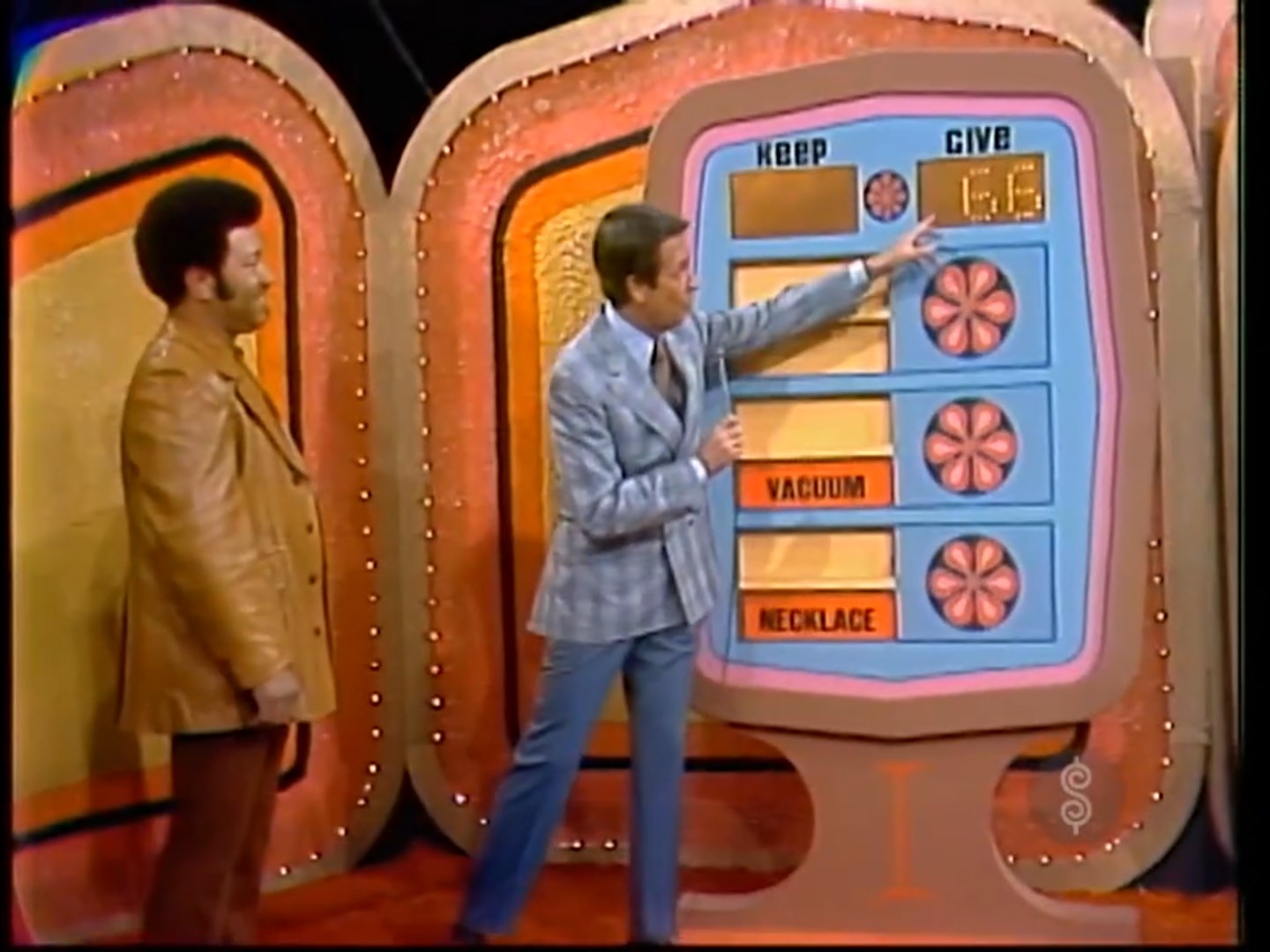 Contestant and host interacting at the Give or Keep game on The Price is Right, displaying the prize values on a colorful game board.