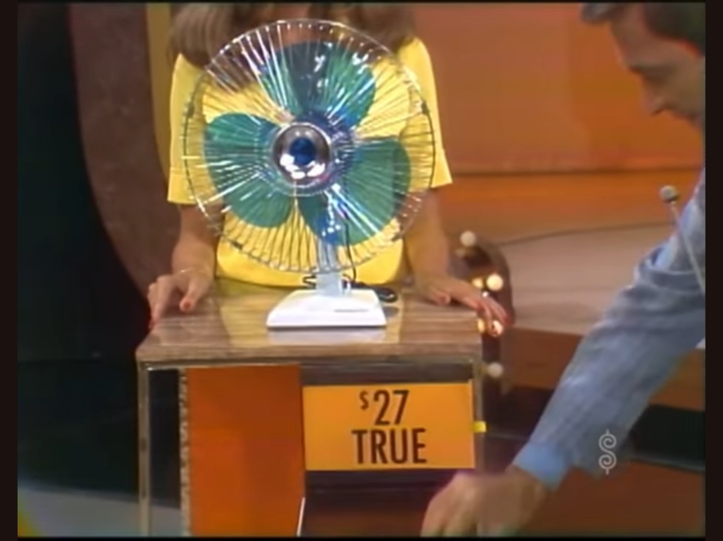 A model wheels out a fan priced at , labeled as 'TRUE', while a male host gestures beside her.