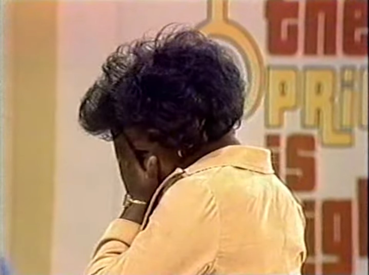 Contestant showing disappointment while hiding her face during The Price is Right game show.