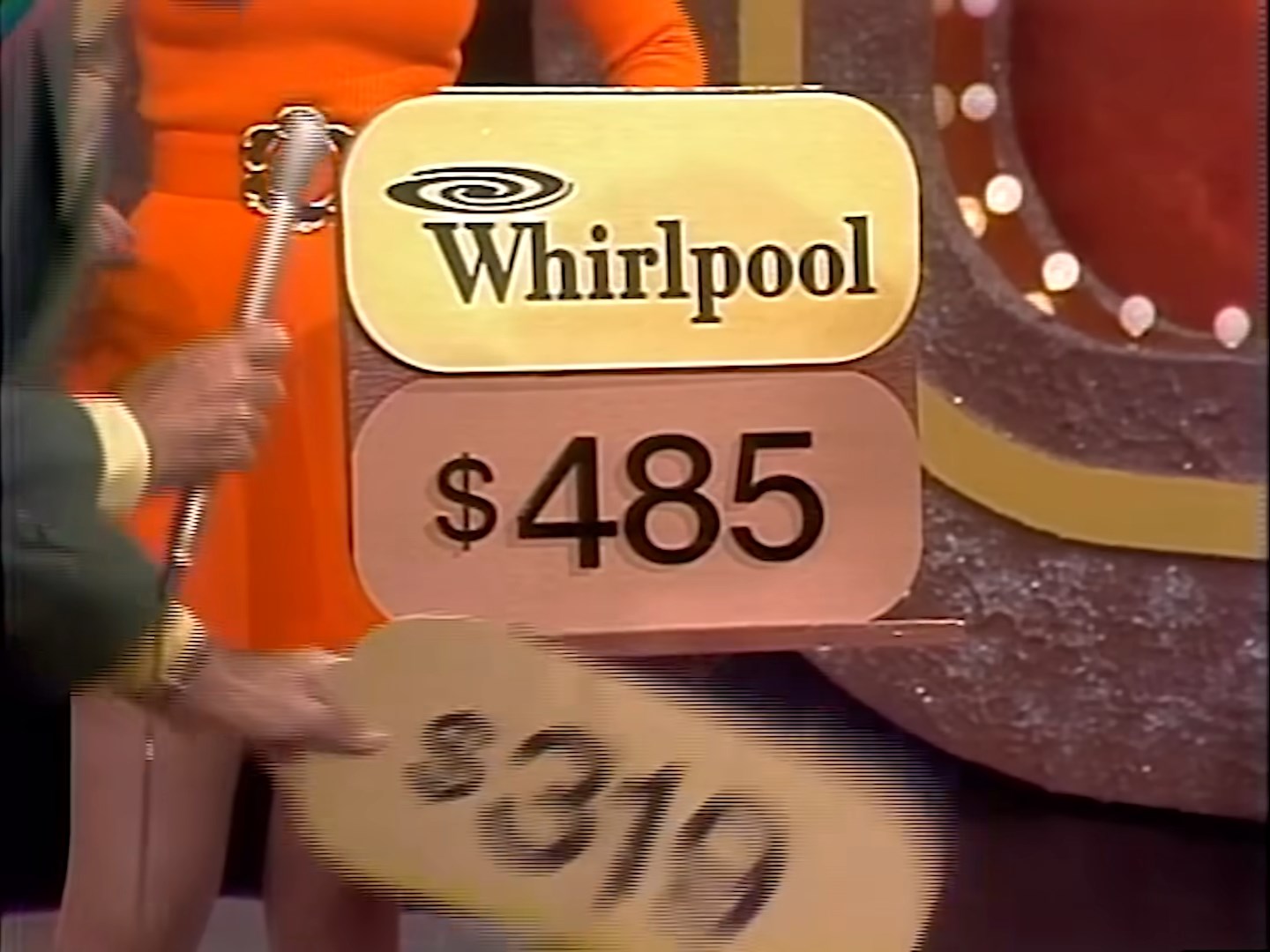 Host revealing two price tags for a Whirlpool refrigerator, taking away the 9 tag, leaving the 5 tag behind.