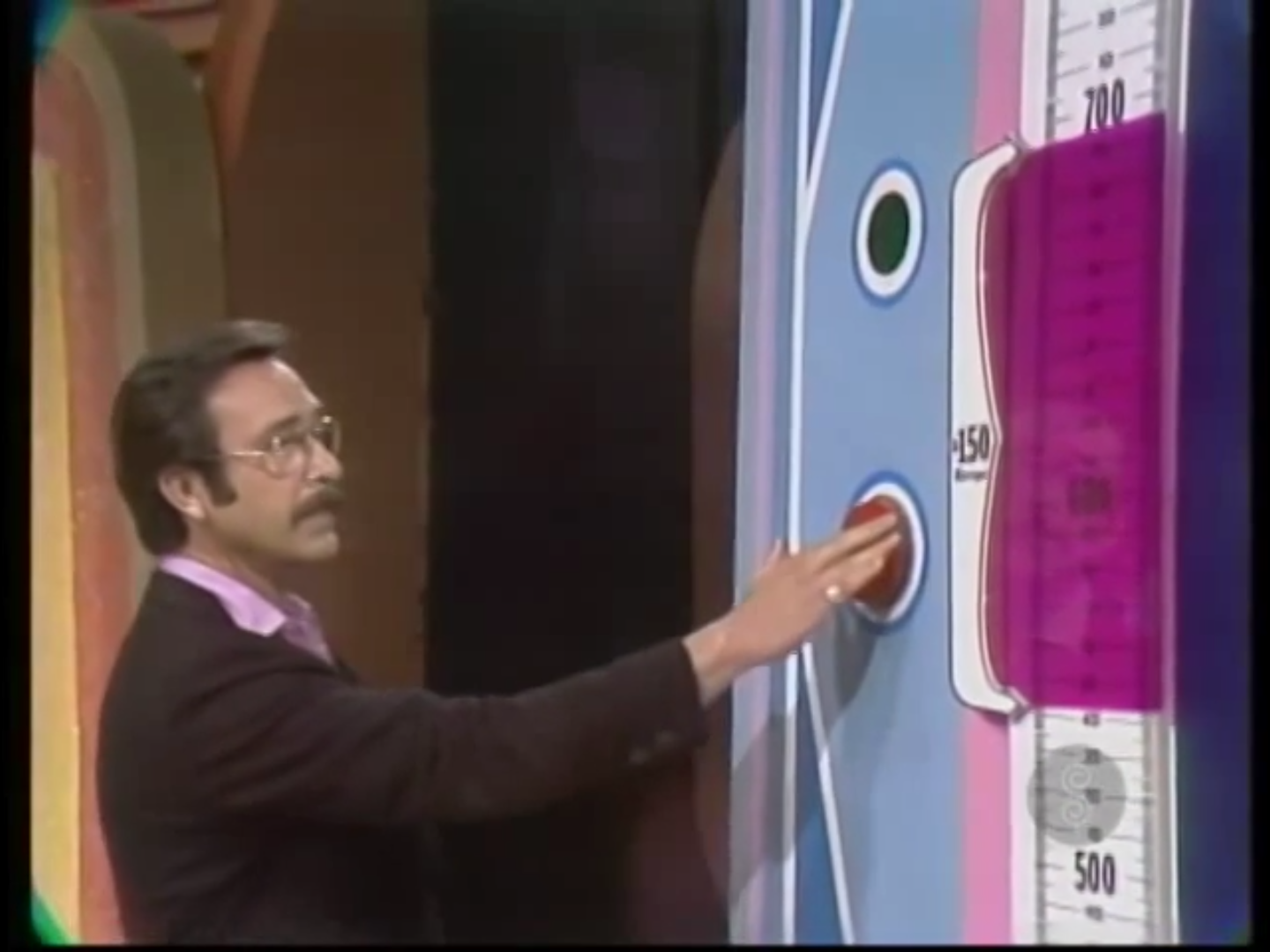 A contestant is ready to press the button to stop the range finder on the pricing scale of The Price is Right's Range Game.