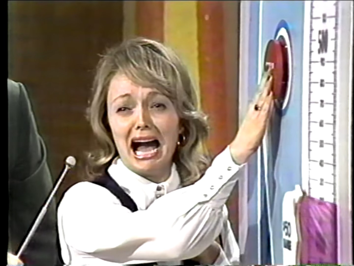 A contestant nervously pressing the button to stop the range movement in the Range Game on The Price is Right.