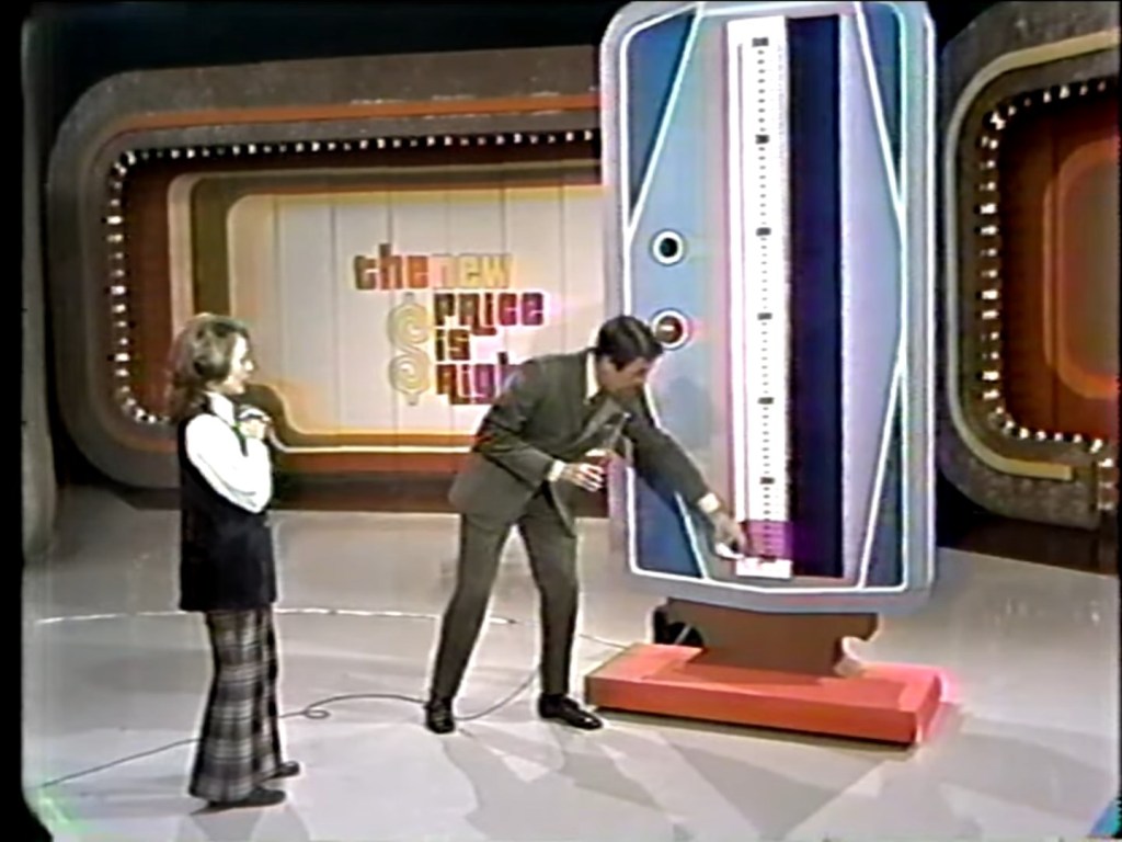 A contestant and host interact with the Range Game display on `The Price Is Right`, showcasing the moving range indicator and the game set design.