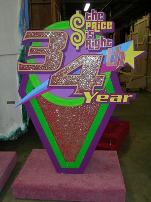 Sign celebrating the 34th anniversary of 'The Price is Right', featuring colorful graphics and glitter.