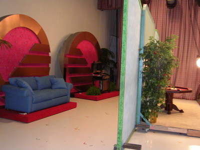 Backstage view at the Season 34 premiere week, featuring a blue couch, decorative elements, and a table in the set.