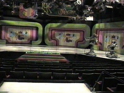The set of a television studio featuring colorful walls, stage area, cameras, and seating for an audience.