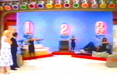 A Most Expensive game featuring three large numbers '1', '2', and '3' on a colorful background, with contestants and hosts interacting on stage.