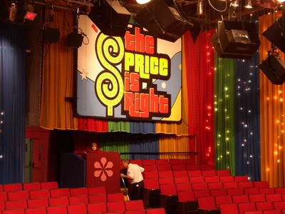 Interior of the Bob Barker Studio featuring the colorful backdrop of 'The Price is Right' with red seating and stage equipment.