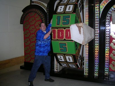 Marc Green is interacting with a large spinning wheel from The Price is Right.