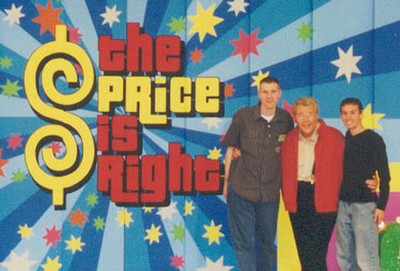 Two guests posing with a host in front of a colorful backdrop featuring the show's title 'The Price is Right.'