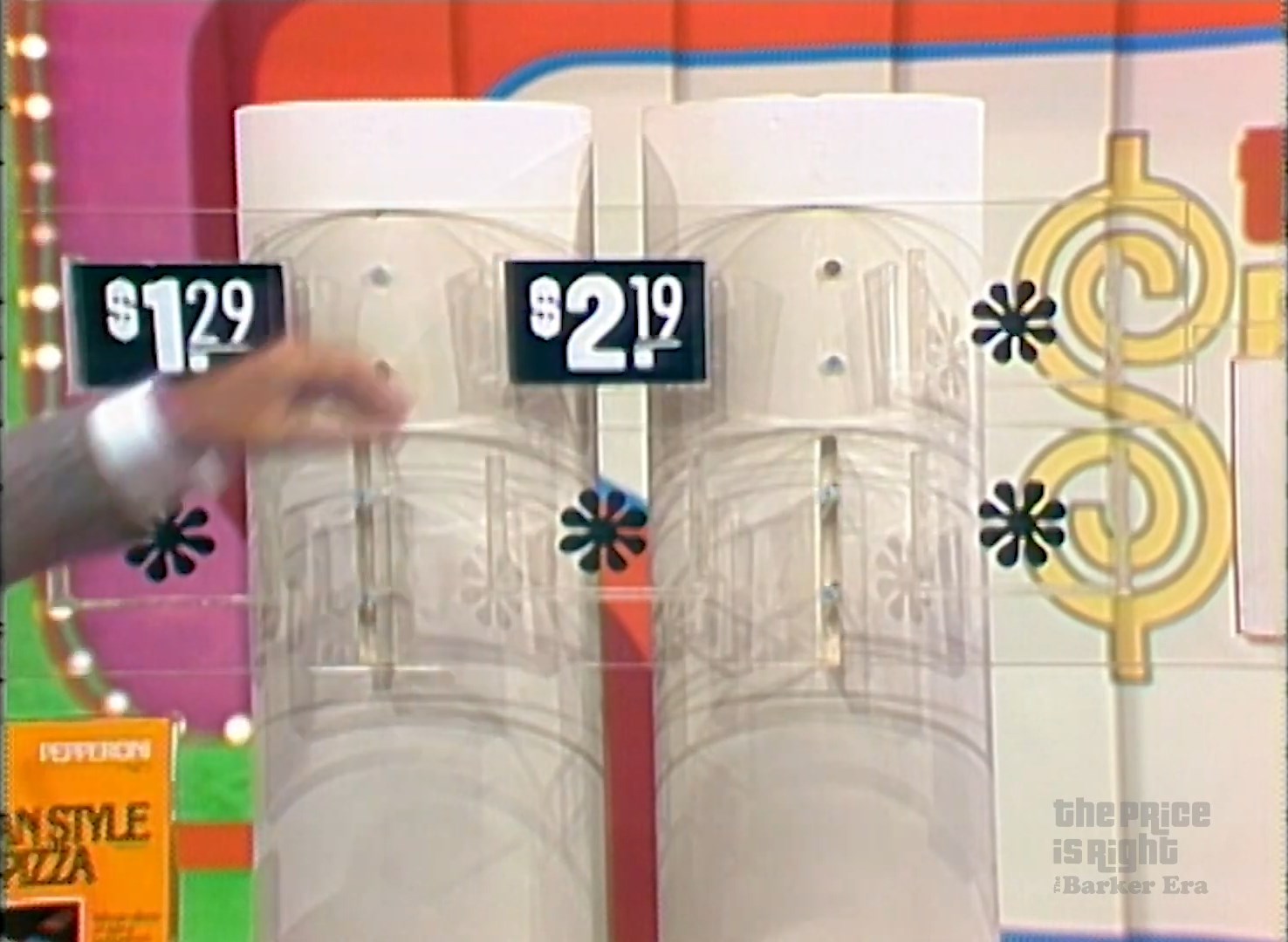 Two price tags displaying .29 and .19 for a pricing game on The Price is Right, with a hand gesturing towards the tags.