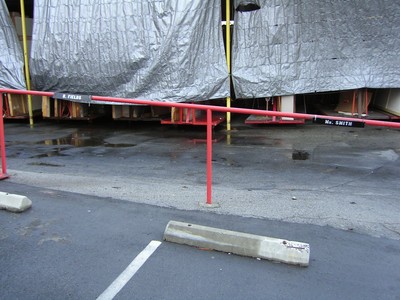 A parking area with a red railing labeled 'R. Fields' and 'Mr. Smith' in front of a covered structure.