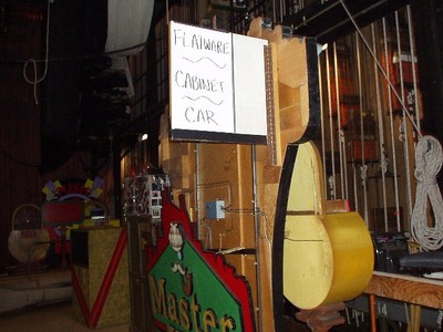 The back of Master Key's wooden structure with a sign labeling items such as 'Flatware,' 'Cabinet,' and 'Car."
