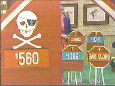 A Danger Price game display from The Price is Right featuring a pirate skull and crossbones along with price tags for various items, including 'CHAIRS' and 'BAR GLOBE.'