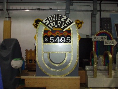 A display from a pricing game called 'Squeeze Play' featuring the price $5,495, set in a storage area decorated with colorful elements.