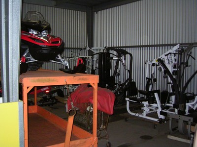 A storage area inside the Bob Barker Studio featuring various gym equipment, including exercise machines and a snowmobile.