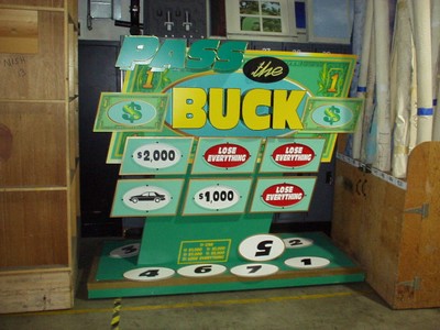 A game board for "Pass the Buck" featuring dollar amounts and options like $2,000 and $1,000, with the phrase 'LOSE EVERYTHING' displayed.