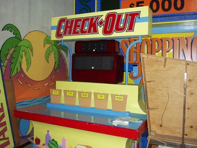 A colorful pricing game display labeled 'CHECK-OUT' featuring five bins with prices, set against a vibrant backdrop.