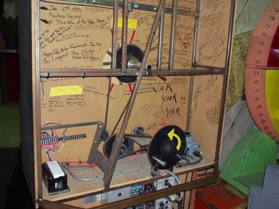Detailed view of the backside of Freeze Frame machinery cabinet with wires and parts, featuring autographs and messages written on the surface.