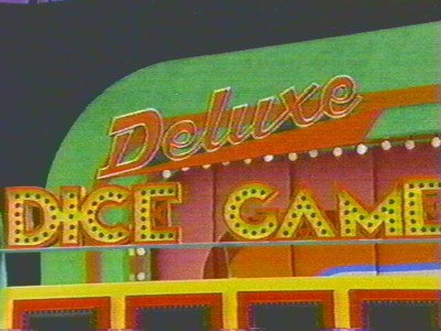 Signage for the Deluxe Dice Game on a colorful game show set.