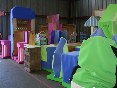 Colorful set pieces and props from the Pricing Games at CBS Television City, featuring various chairs and game elements in vibrant purples, greens, and pinks.