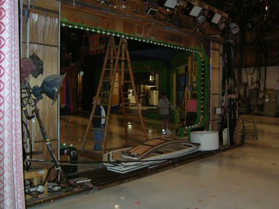 Interior view of Bob Barker Studio with crew members and equipment, including a ladder and stage materials, during setup.