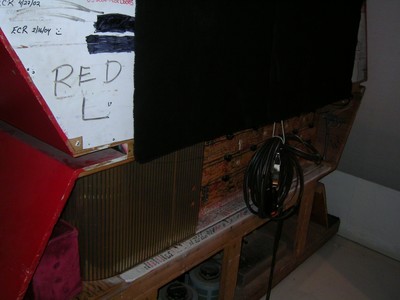 Close-up of the back of One Away, a wooden structure with black fabric and a cable, annotated with the word 'RED'.