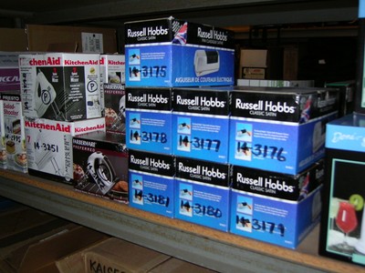 Shelves displaying boxed Russell Hobbs products, including models 3175, 3176, 3177, and 3180, alongside KitchenAid appliances.