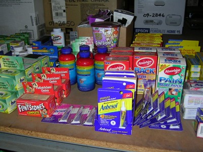 Table displaying various over-the-counter medications and health products, including vitamins, pain patches, and oral care items.