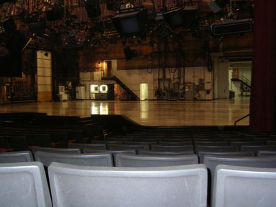 View of the Bob Barker Studio stage from the audience seating area, showing the empty stage and lighting equipment above.