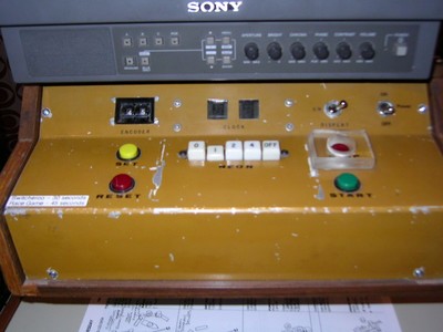 Close-up view of a vintage game control panel featuring buttons labeled 'RESET', 'START', and various switches, with a Sony display panel above.