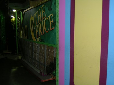 A partially visible set piece featuring the iconic logo 'The Price Is Right' against a colorful background in a game show studio.