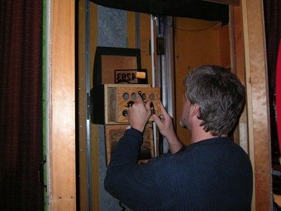 Big Dave adjusting a control panel for Range Game in a backstage area of a television studio.