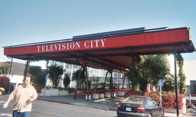 Exterior view of the Television City building with a red canopy and signage.