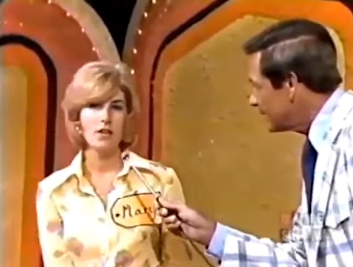 A contestant named Mary on The Price is Right, during the Shell Game segment, speaking with the host who is holding a microphone.